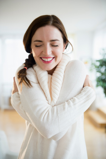 Woman giving herself a hug, smiling